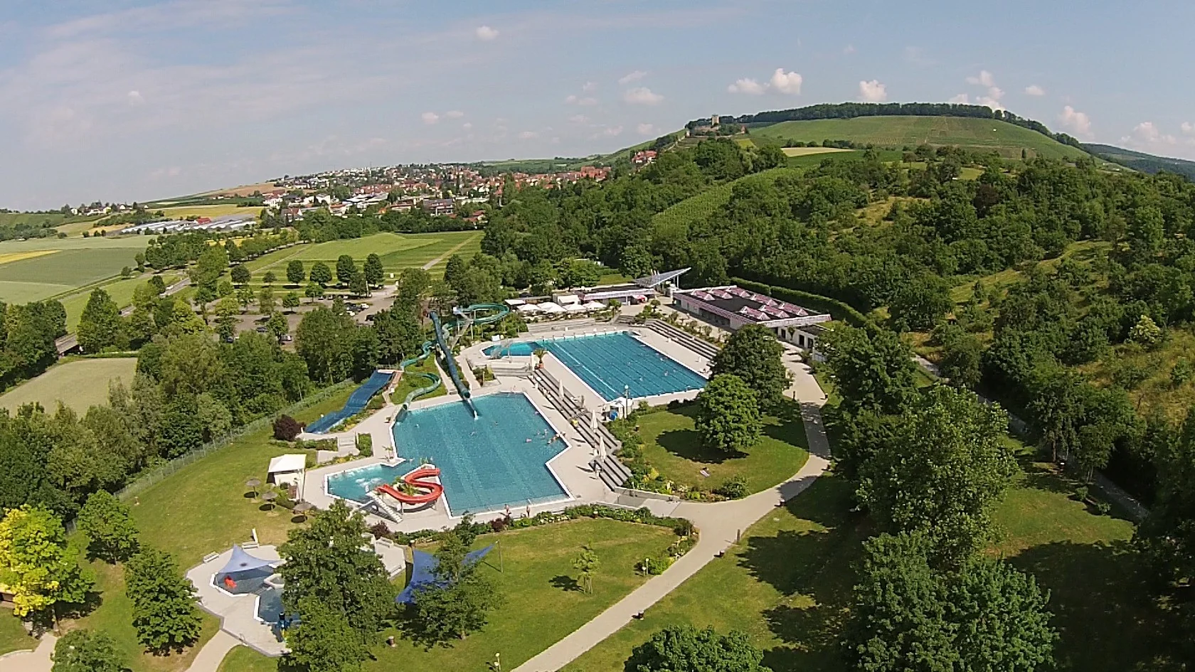 Sommerlicher Blick über die Wasserwelten und Liegewiesen des Mineralfreibads